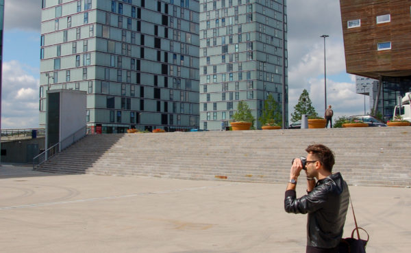 Mann fotografiert die Hochhäuser "Side by Side" in Almere
