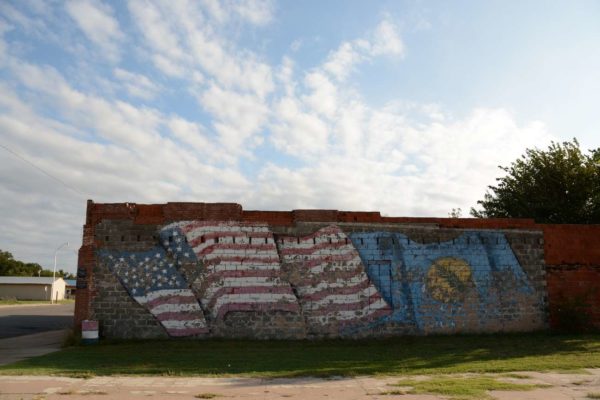 Verblichene amerikanische Flagge auf einer Hauswand in Erick, Oklahoma