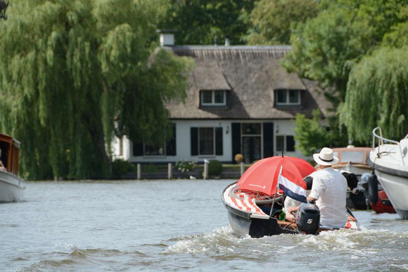 Ein Mann mit Hut einsam in einem Boot auf der Vecht in Holland