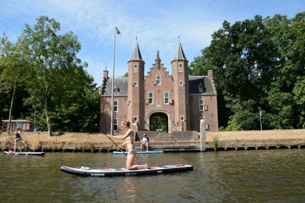 Stand-up-Padddlerin auf der Vecht vor einem kleinen Schloss in Holland