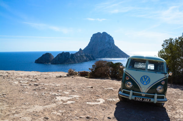 Ein VW Bully auf einem Felsen mit Blick auf Es Vedra auf Ibiza