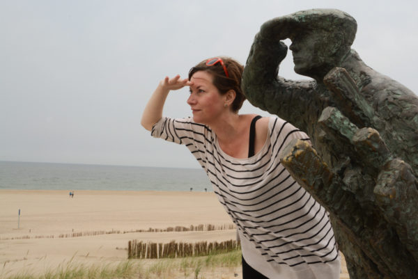 Frau mit Statue am Strand von Camperduin in Nordholland