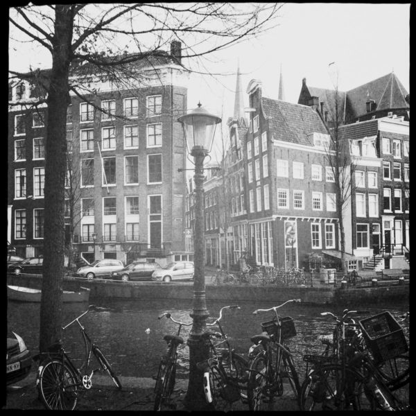 Amsterdam wie im Bilderbuch: Fahrräder, schiefe Häuser, Gracht und Laterne