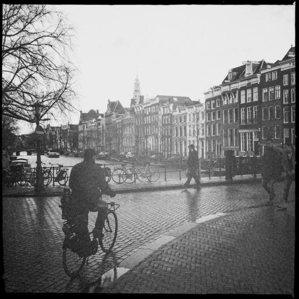 Fahrradfahrer im Grachtengürtel mit der Westerkerk im Hintergrund