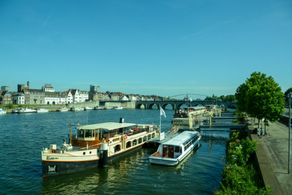 Die Maas in Maastricht mit Ausflugsschiffen und Brücken an einem herrlichen Sommertag