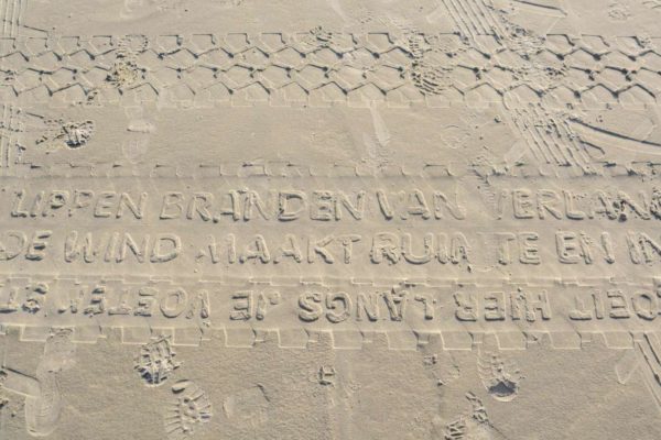 Das Amphibienfahrzeug Vliehors Express hinterlässt mit seinen Reifen ein Gedicht im Sand