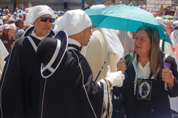 Geistliche mit Sonnenschirm und Sonnebrille in der süitalienischen Stadt Lecce in Apulien