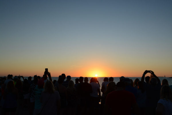 Menschenmenge in Key West feiert den Sonnenuntergang mit Anekdoten über Hemingway und Havanna