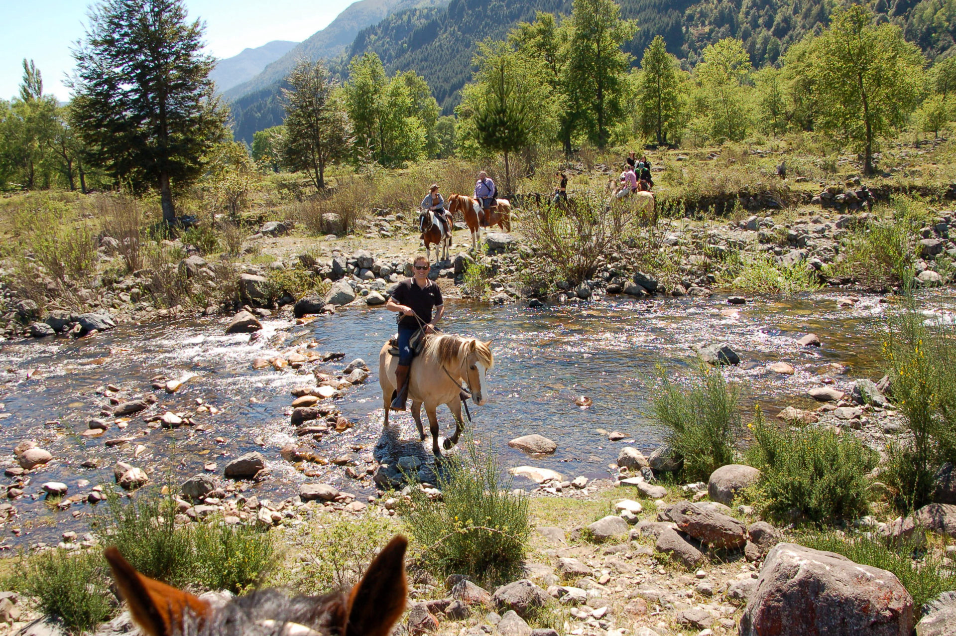 Autor Ralf Johnen überquert auf einem Pferd einen Fluss in Chile