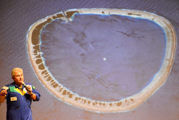 Astronaut in Florida mit Bildern des Bikini-Atolls aus dem Weltraum