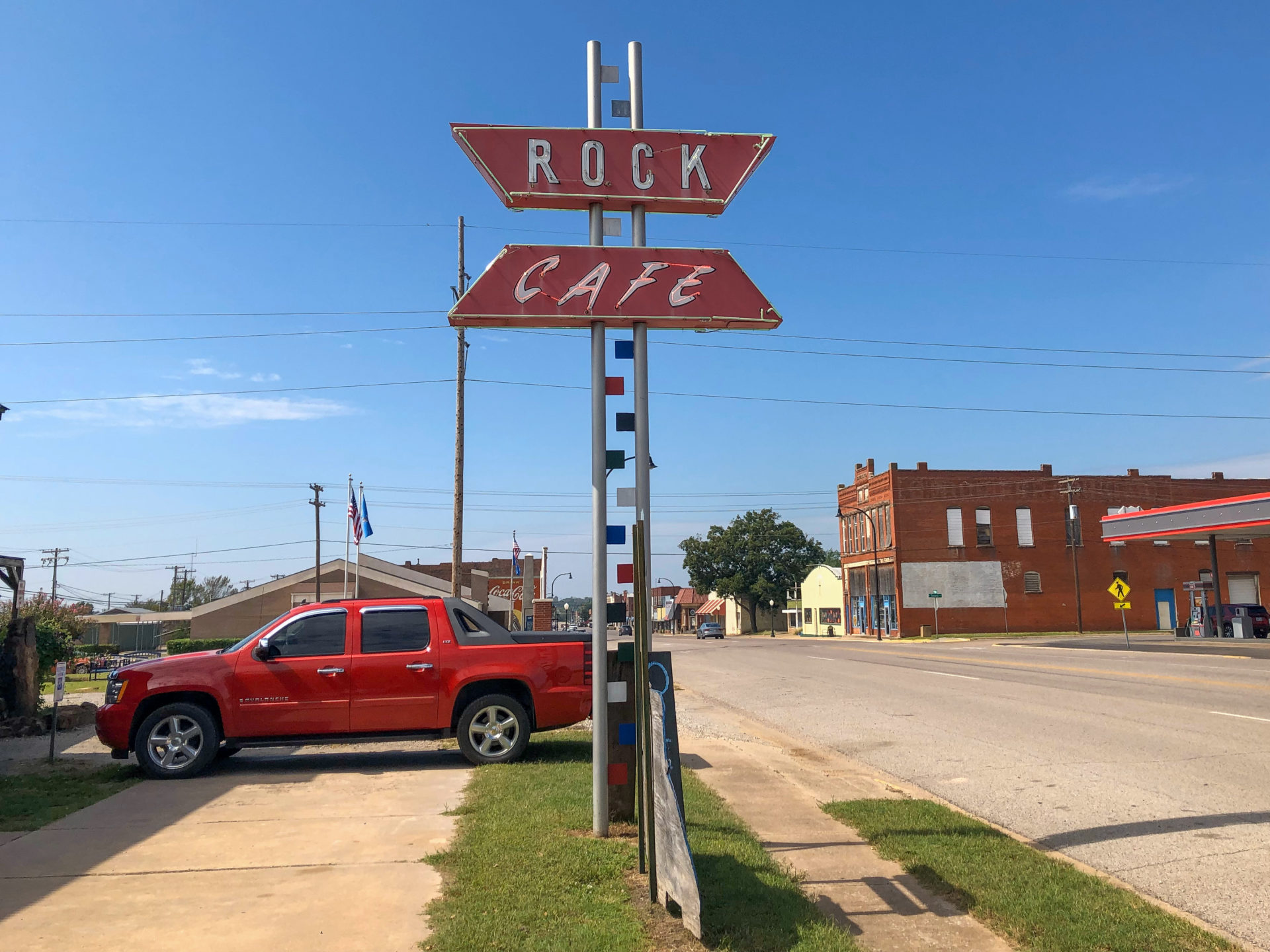 Das Schild des Rock Café in Oklahoma mit Pick-up und viel Asphalt