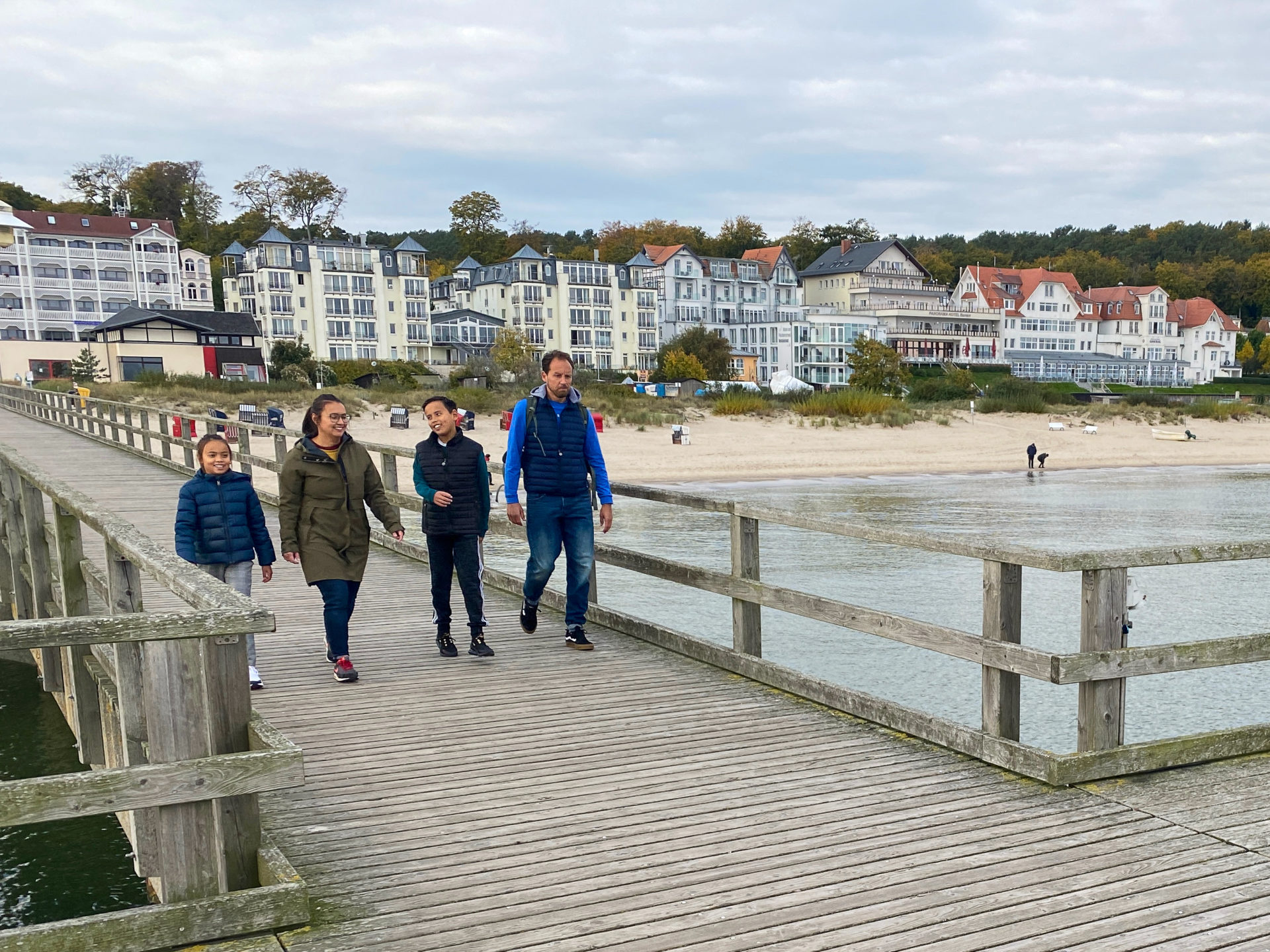 Glückliche Familie auf einer Seebrücke auf Usedom mit Bäderarchitektur im Hintergrund