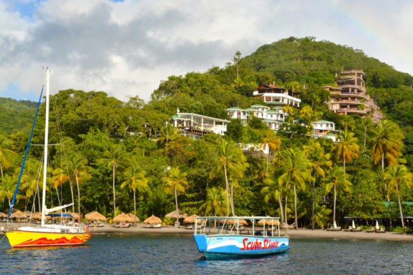 Yachten und ein Hang mit Hütten und Palmen auf der Karibikinsel Saint Lucia