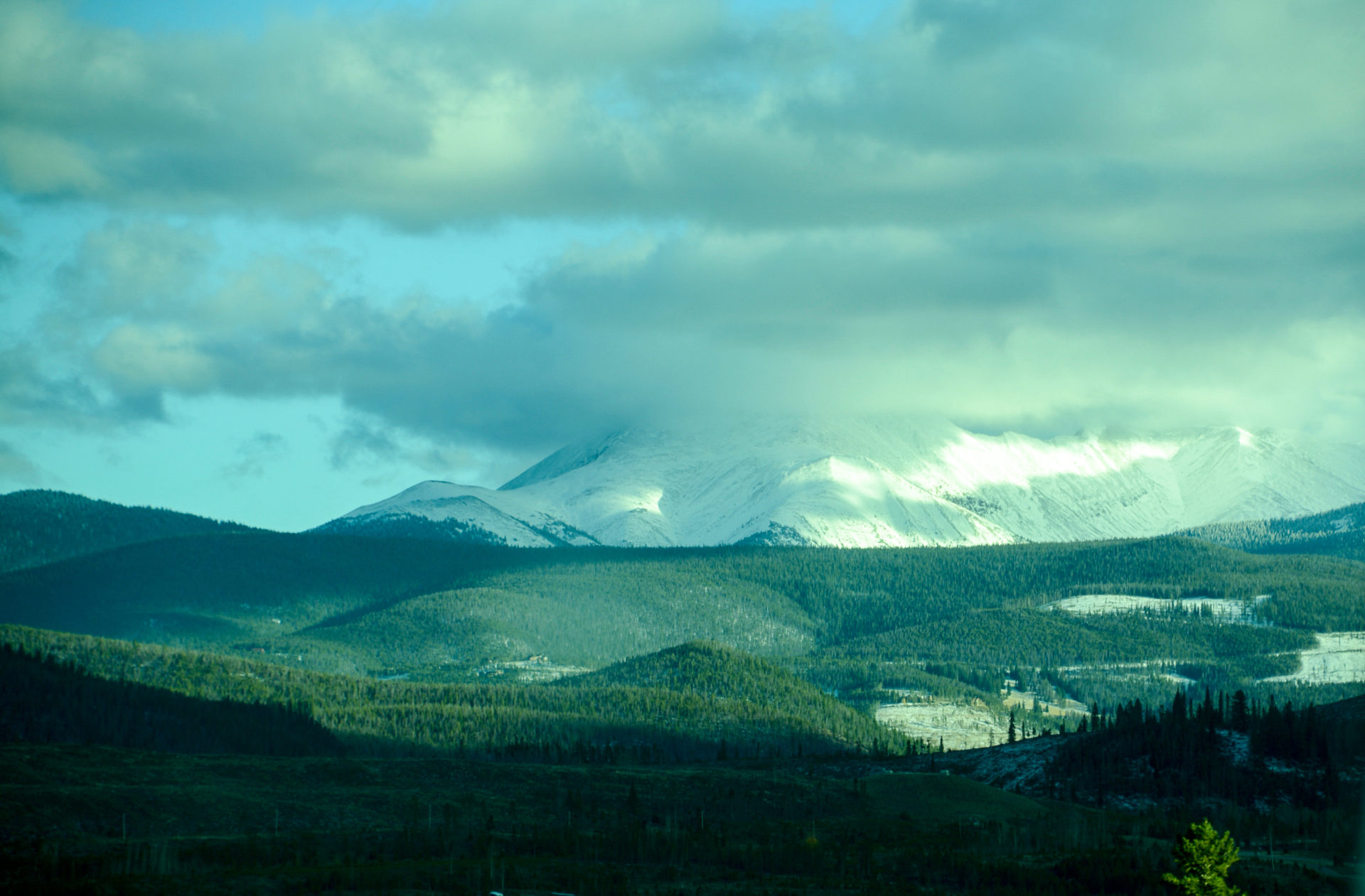 Wald, Schnee und Wolkenfelder in den Rocky Mountains