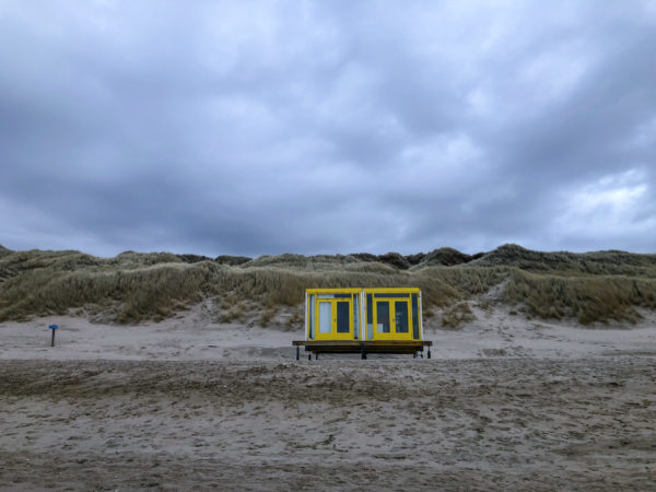 Zwei winzige Strandhäuser vor den Dünen der niederländischen Nordseeküste