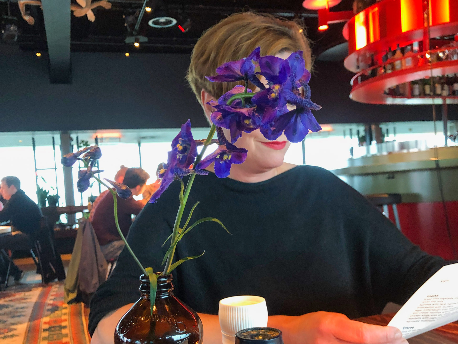 Frau mit Blumen am Tisch im Restaurant Canvas in Amsterdam