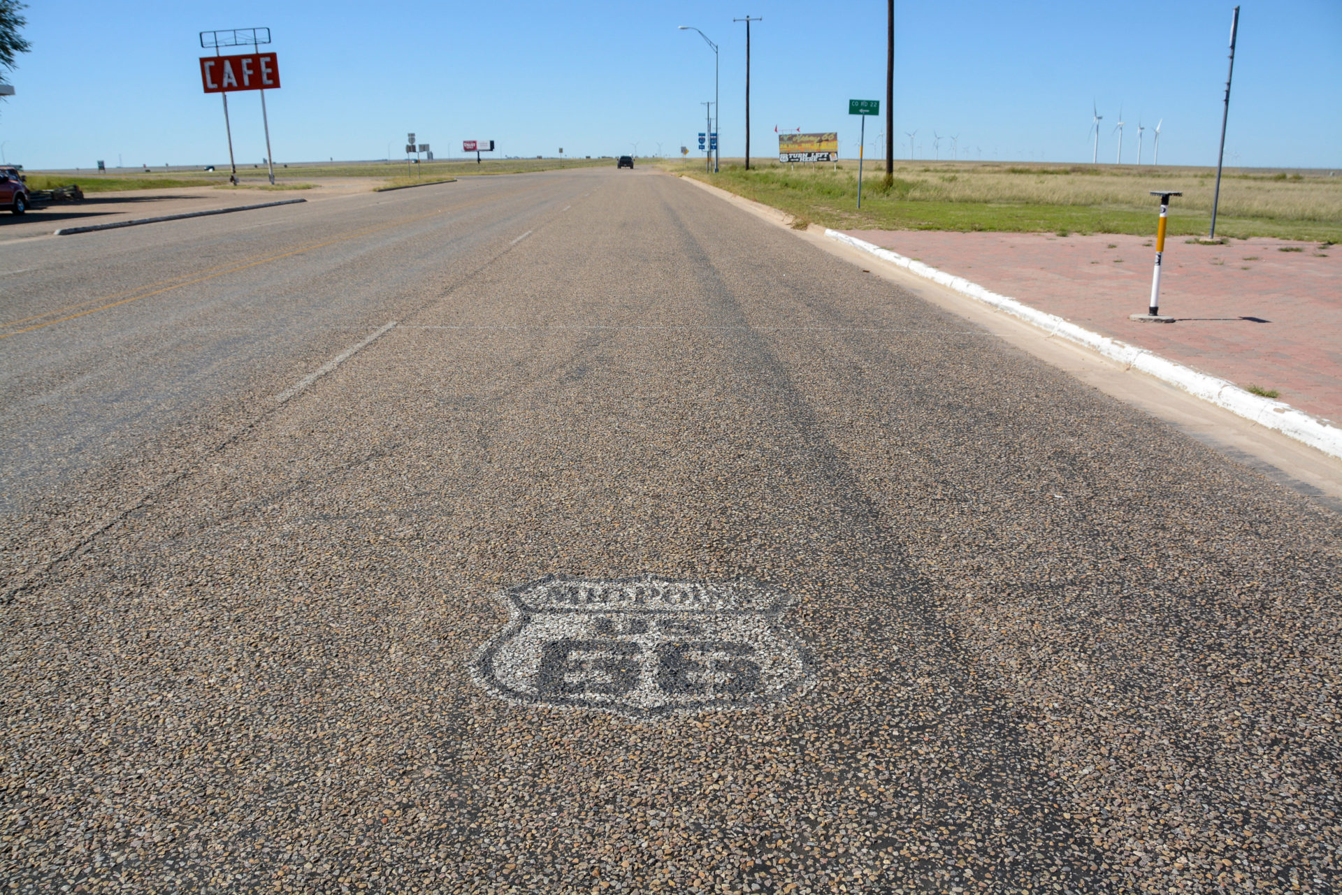 Viel Asphalt der Route 66 in Adrian im Bundesstaat Texas mit verblichenem Logo