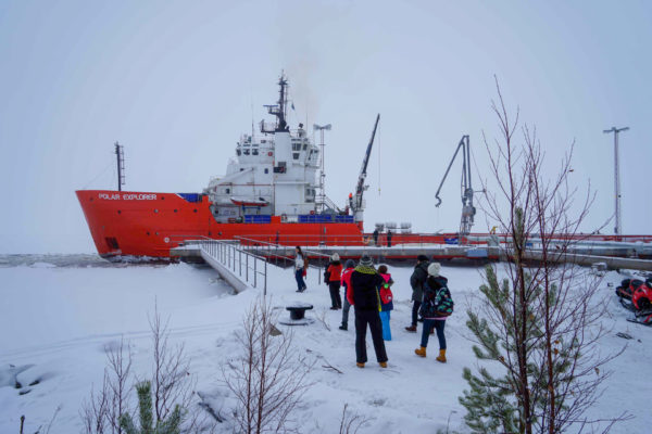 Passagiere gehen an Deck der Polar Explorer im Hafen von Rovaniemi