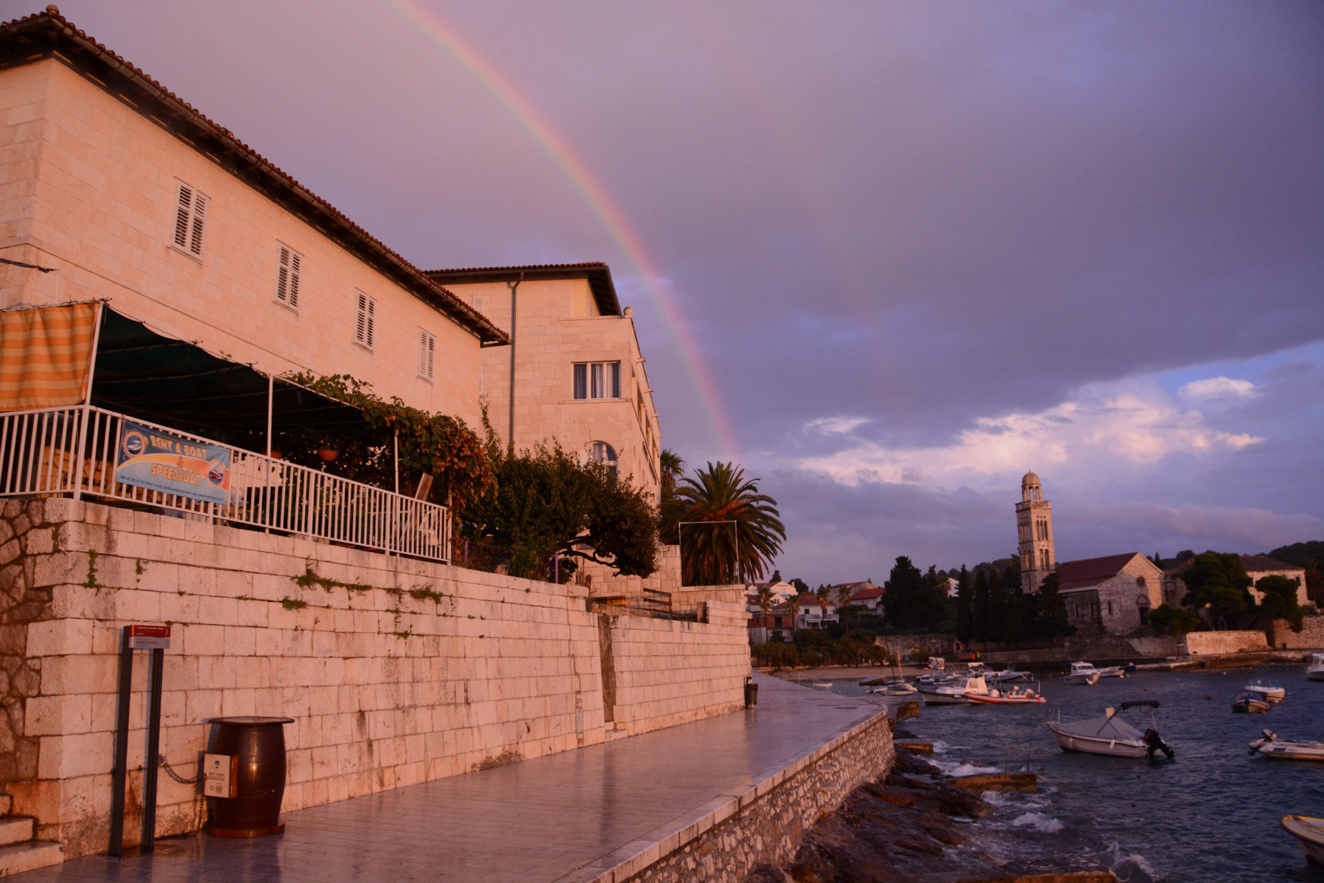 Regenbogen über Steinhäusern auf der dalmatischen Insel Hvar mit Blick auf den Hafen
