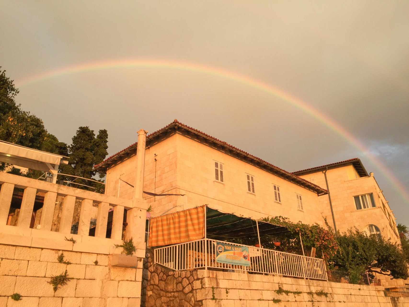 Regenbogen über Steinhäusern auf der dalmatischen Insel Hvar