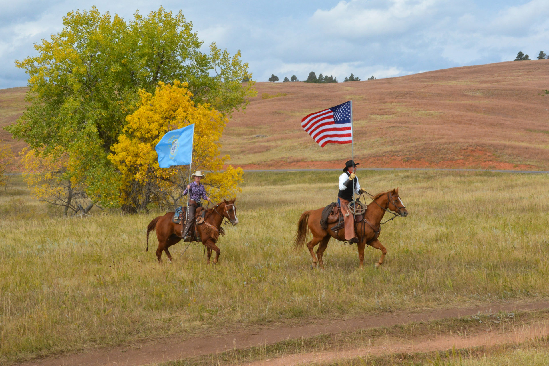Reiter beim Buffalo Roundup in South Dakota mit Flaggen der USA und South Dakota