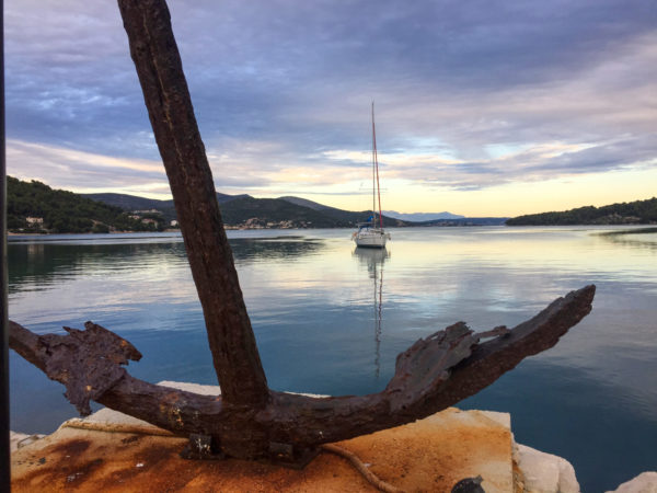 Anker mit Segelboot in kroatischem Hafen in der Morgendämmerung