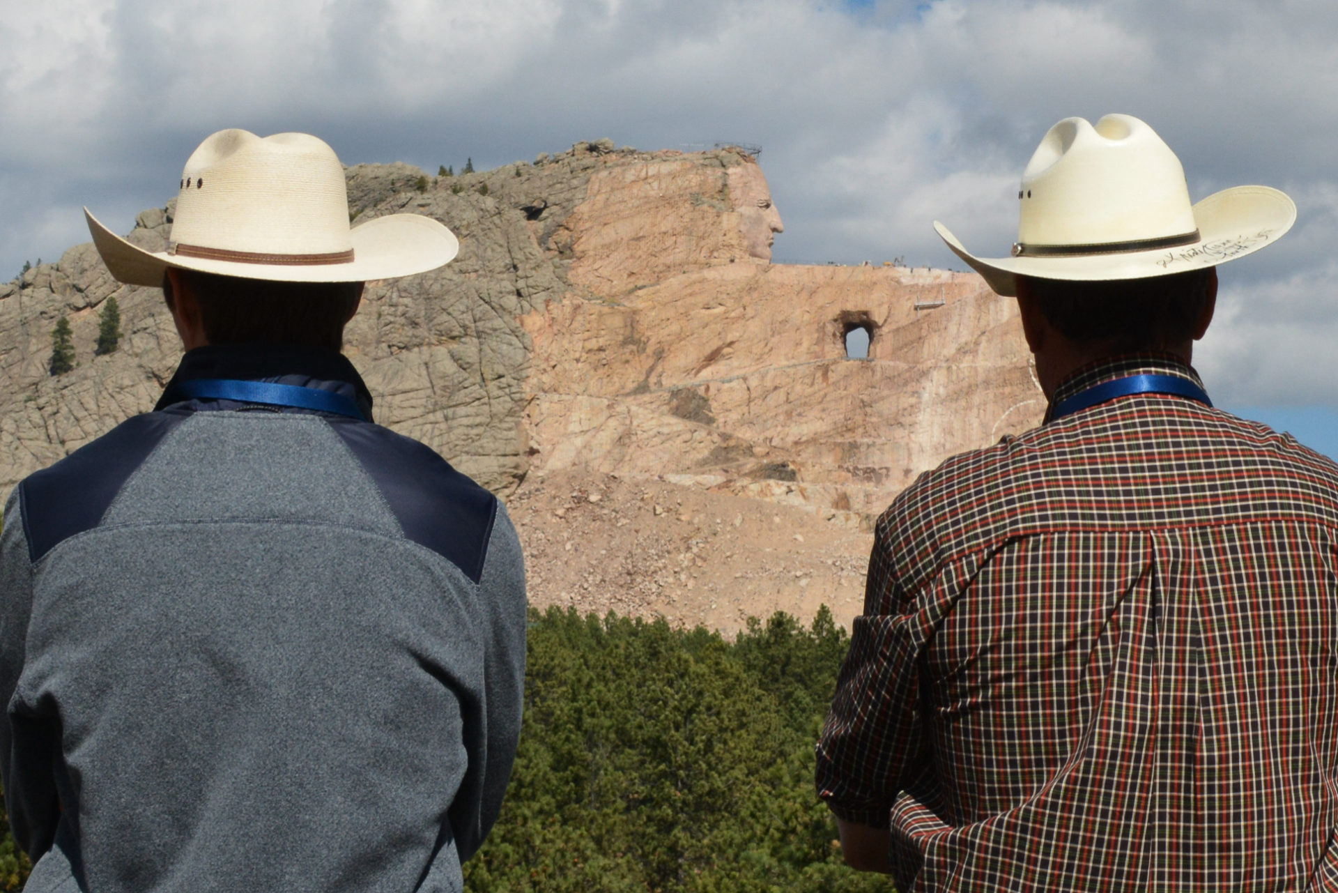 Zwei Cowboys blicken auf das Crazy Horse Memorial in South Dakota