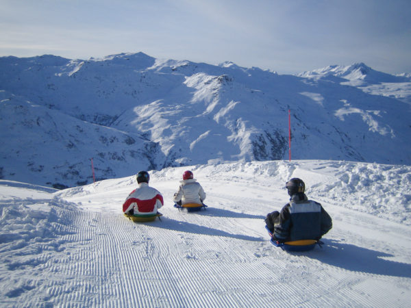 Drei Rodler machen sich an eine Abfahrt bei Les Menuiren in den Alpen