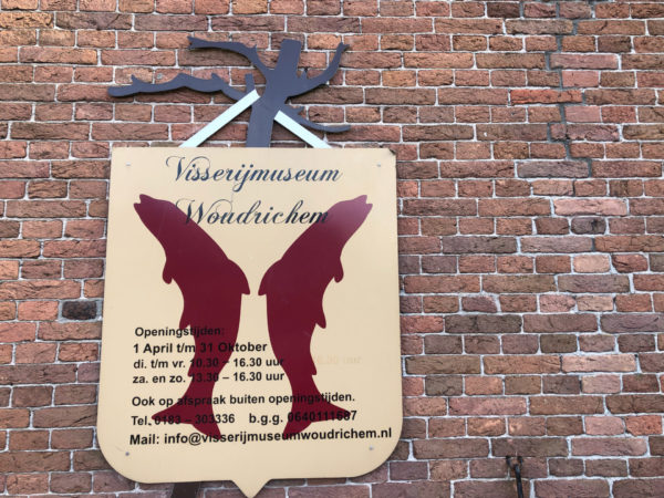 Ein Schild an der Wand des Fischereimuseums von Woudrichem erklärt, wie es den Lachsen im Rhein ergangen ist