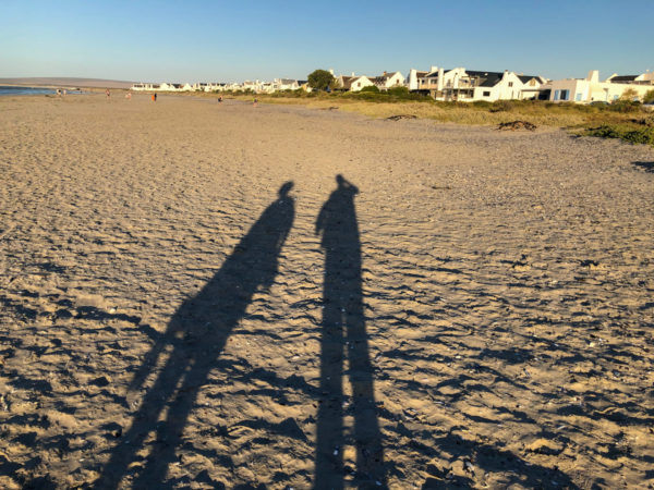 Lange Schatten auf dem Strand von Paternoster in Südafrika