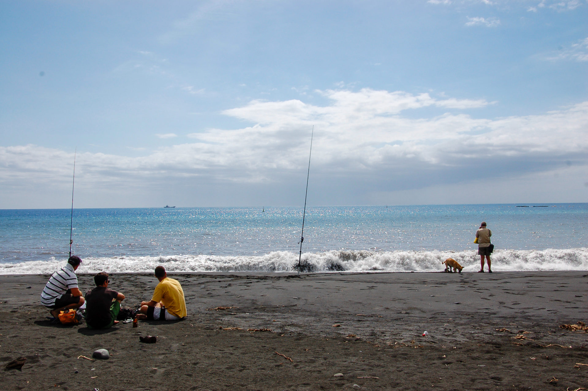 Schwarzer Strand mit Anglern bei Saint Denis auf der französischen Insel La Réunion