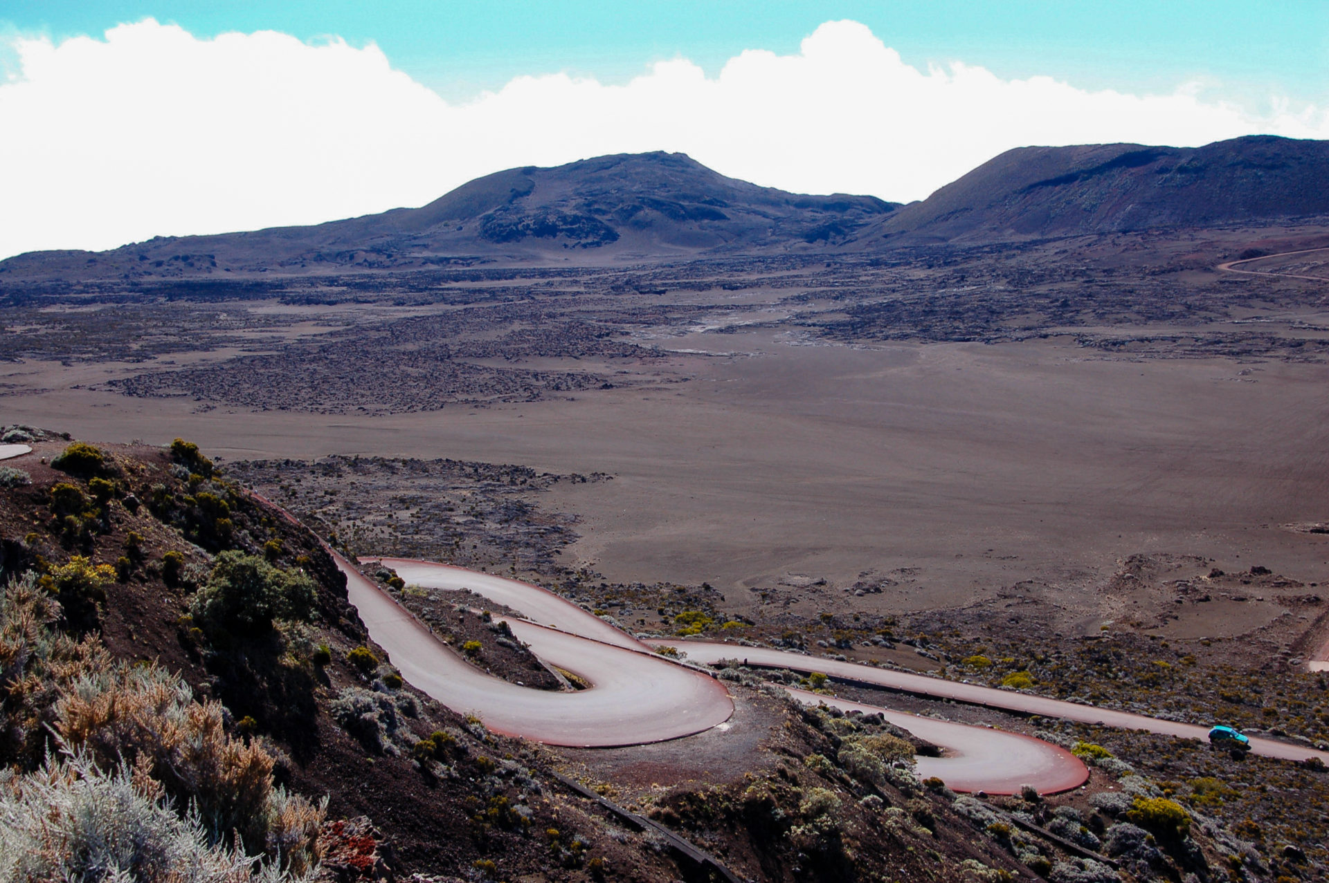 Serpentinen führen aus einem Vulkankegel auf La Réunion zur Küste
