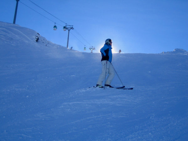 Skifahrerin im Gegenlicht an einem Steilhang in den Trois Vallées in Frankreich