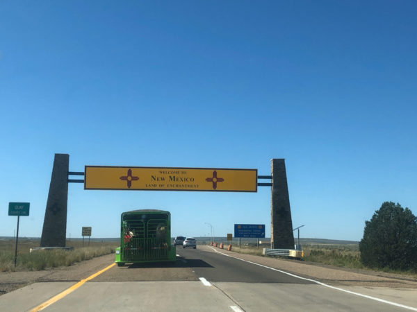 Schild an der Landesgrenze zu New Mexico mit Viehtransporter