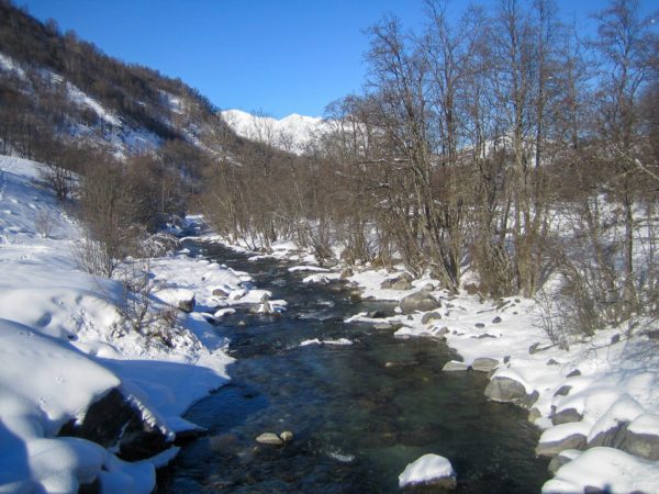 Winterlandschaft mit Bach in den Trois Vallées, dem größten Skigebiet der Welt