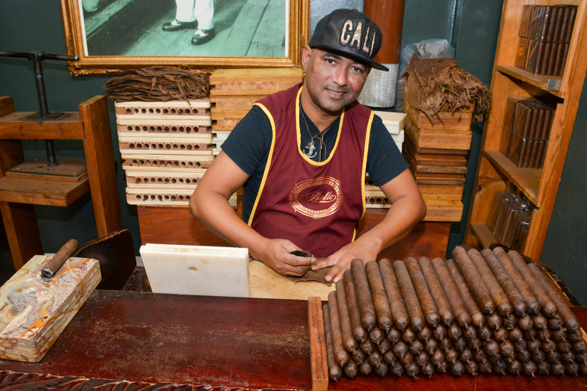 Zigarrendreher mit Baseballmütze mit dem Schriftzug Cali dreht Zigarren aus Little Havana