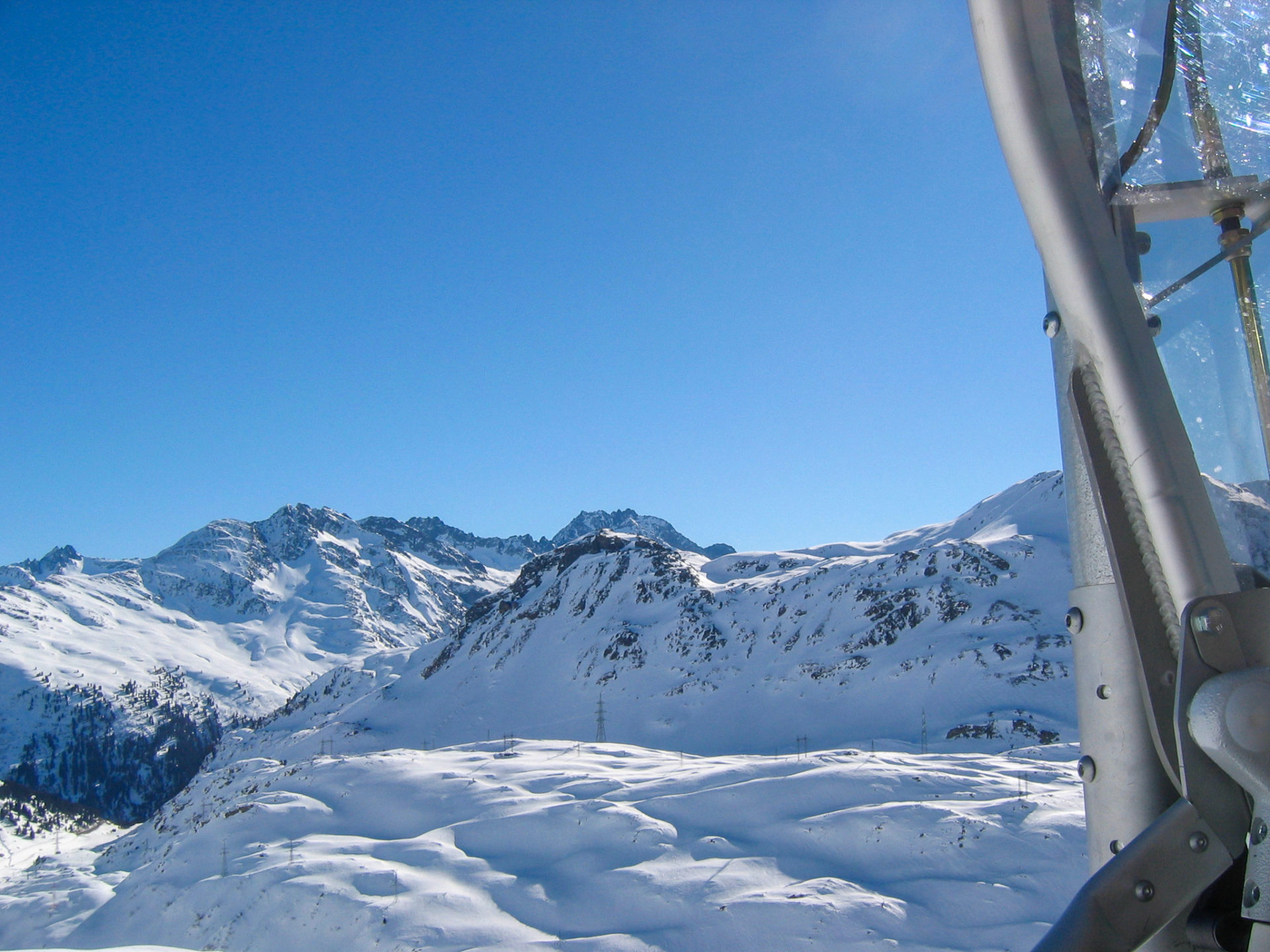 Blick auf der Sesselbahn auf das tief verschneite Alpenpanorama am Arlberg