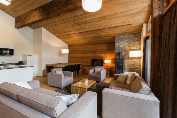Wohnzimmer mit offenem Kamin in der Priva Alpina Lodge in Lenzerheide