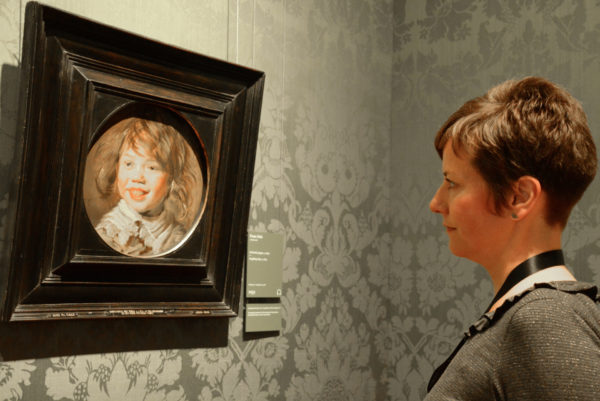 Schöne Frau schaut sich im Mauritshuis von Den Haag ein Porträt von Frans Hals an