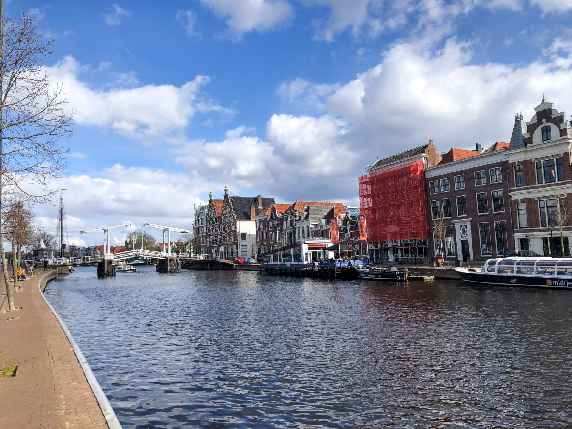 Der Fluss Spaarne in Haarlem bei Sonnenschein mit Giebelbauten und Brücke