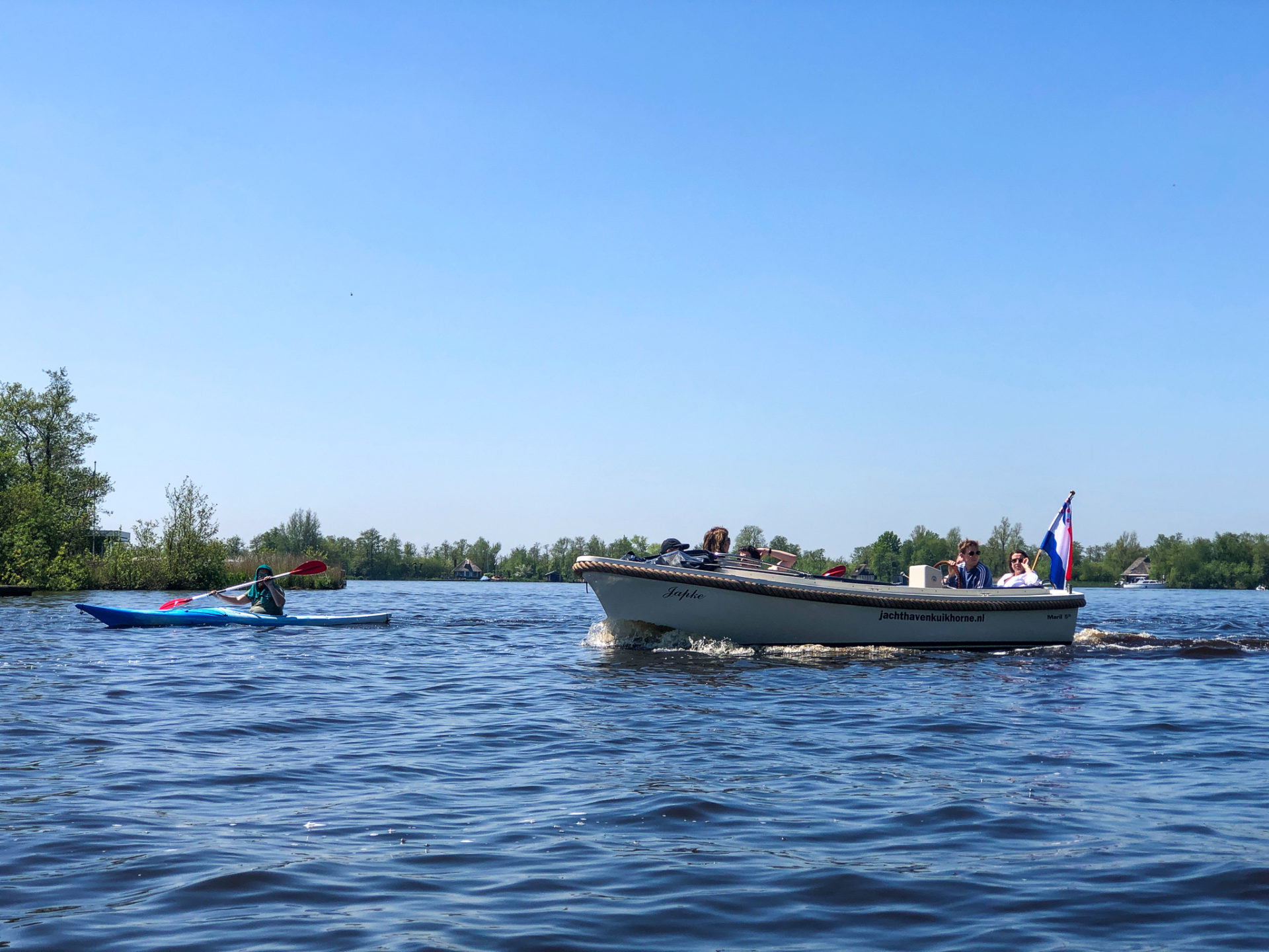 Motorjacht und Kanu im Wasser des Nationalparks Alde Faenen in den Niederlanden