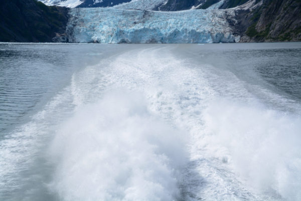 Spritzwasser des Katamarans MS Klondike vor einem Gletscher in Alaska