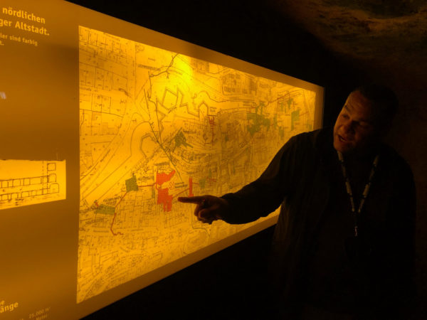 Ein Mann zeigt auf eine Karte der Kellergewölbe unter der Altstadt von Nürnberg