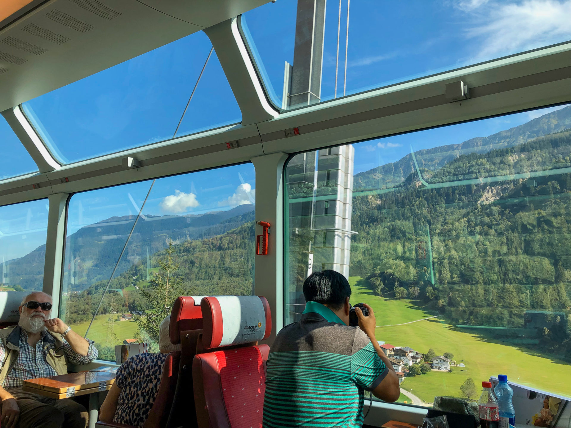 Touristen bewundern die Schweizer Berglandschaft im Glacier Express