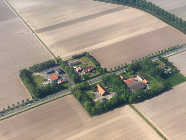 Luftaufnahme von inselartigen Bauernhöfen auf Flevoland umringt von Feldern