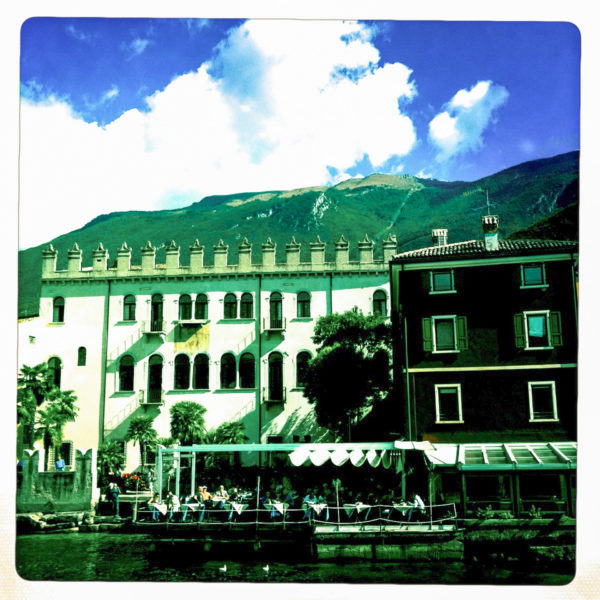 Historische Häuserfassade mit Zinnen und venezianischen Fenstern bei Riva