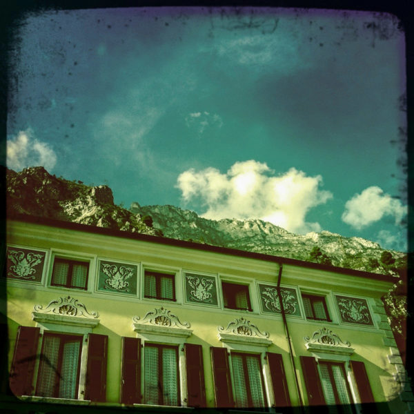 Rokoko-Fassade in Riva am Gardasee mit Bergen im Hintergrund