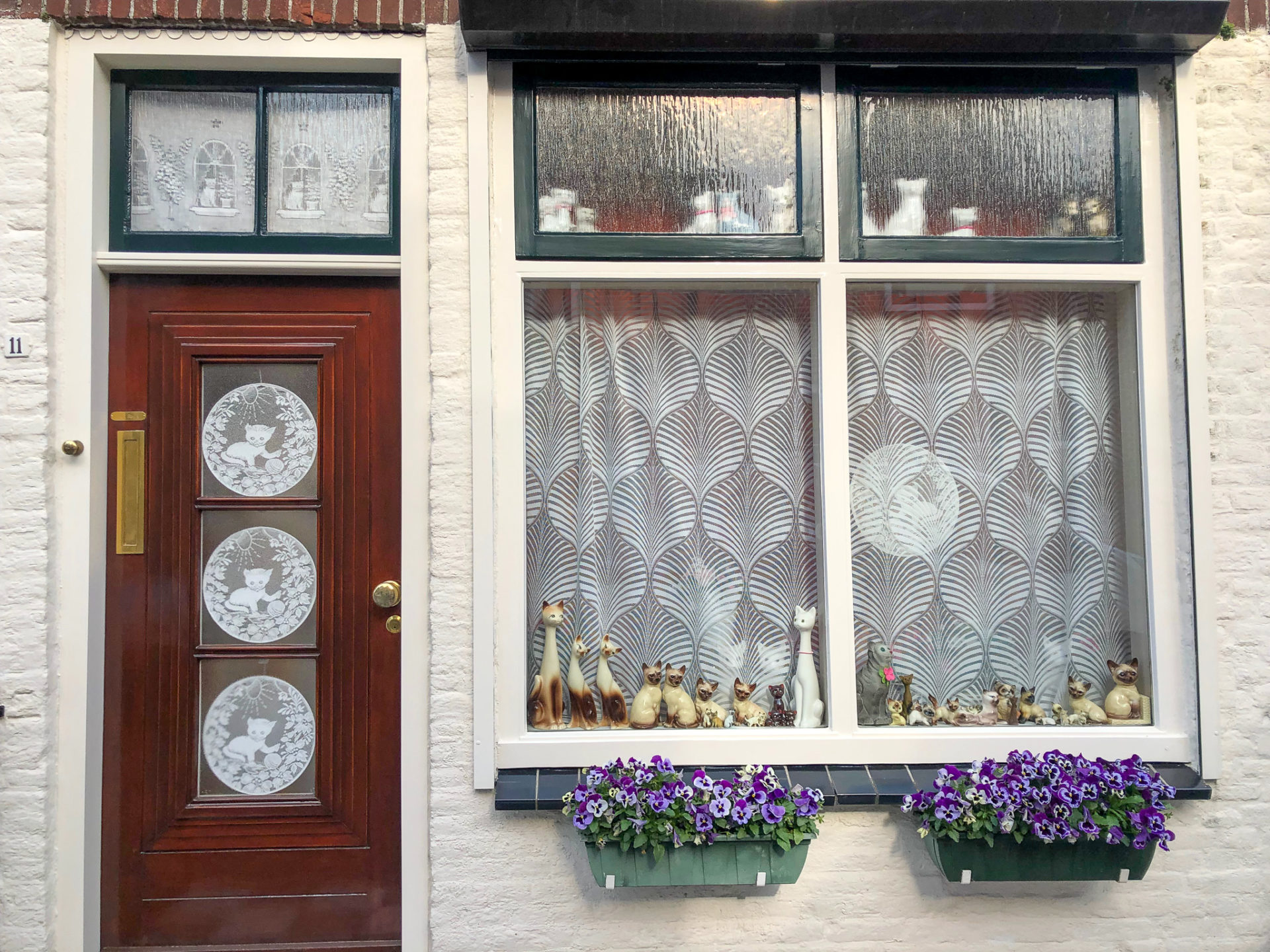 Hausfassade mit Stickereien und Katzen im Fenster in Zierikzee in Zeeland