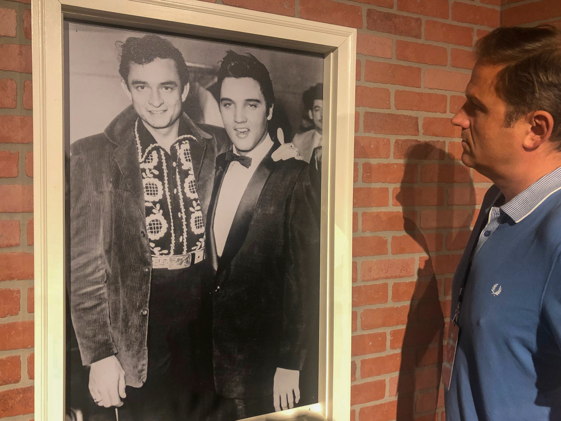 Mann blickt auf Foto von Elvis und Johnny Cash