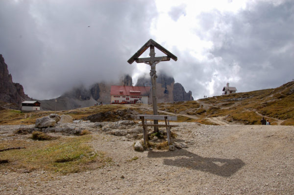 Kreuz mit Berghütte und Kapelle vor den Drei Zinnen in Südtirol
